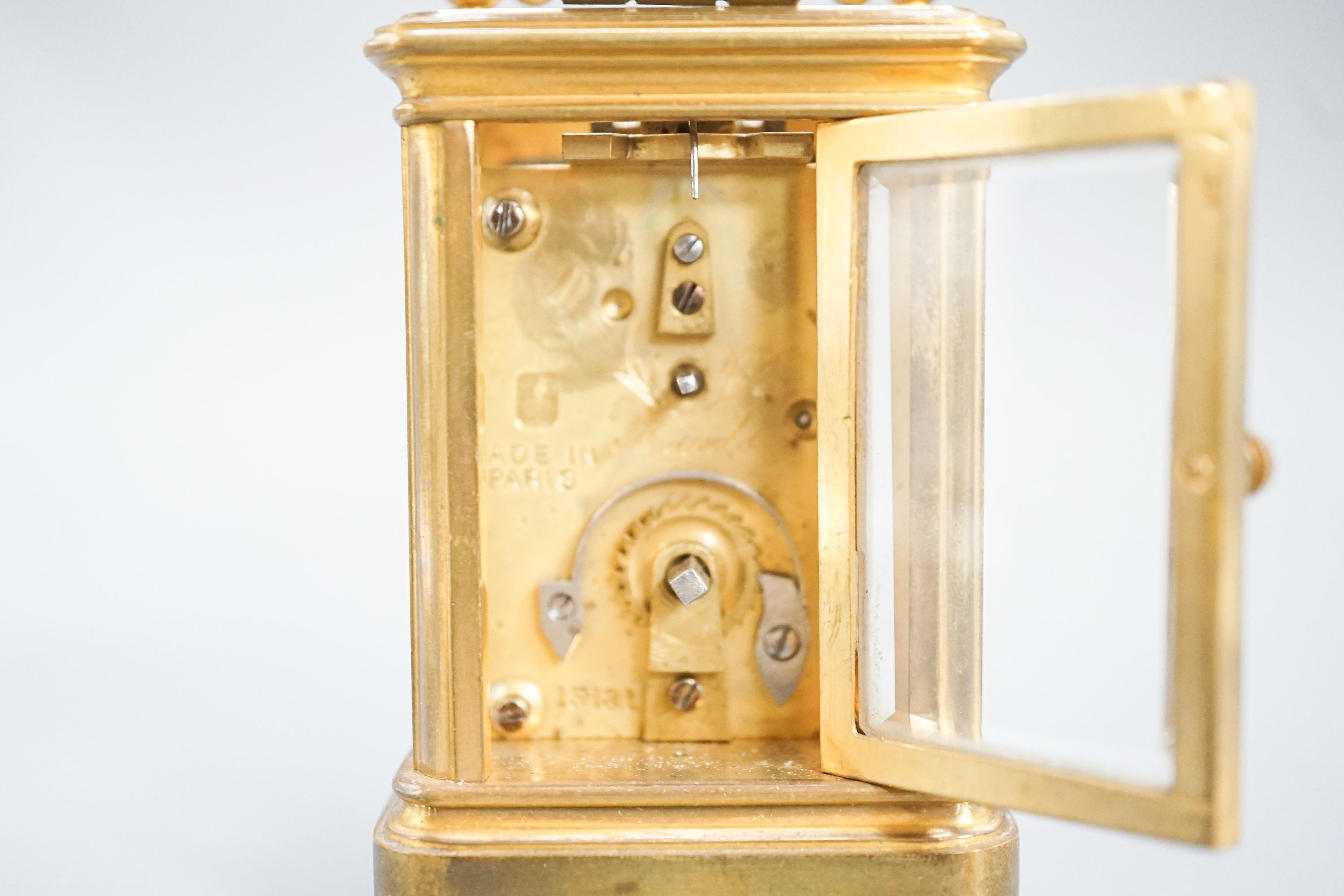 A Henri Jacot brass miniature carriage timepiece, 9.7 cm high with the handle up, cased